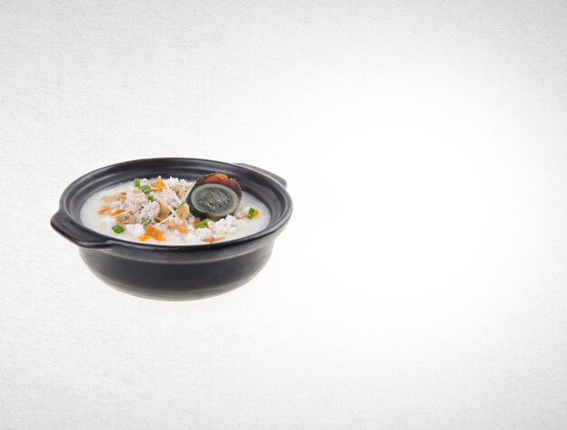 Primer plano de una comida servida en un cuenco contra un fondo blanco