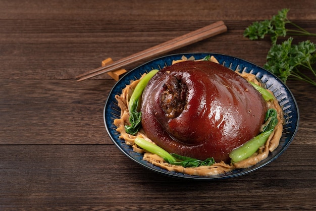 Primer plano de la comida taiwanesa estofado de carne de cerdo en un plato sobre fondo de mesa rústica