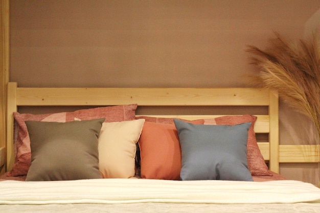 Primer plano de cómodas y coloridas almohadas suaves en la cama Elegante y moderno apartamento decoración del hogar Hygge sca