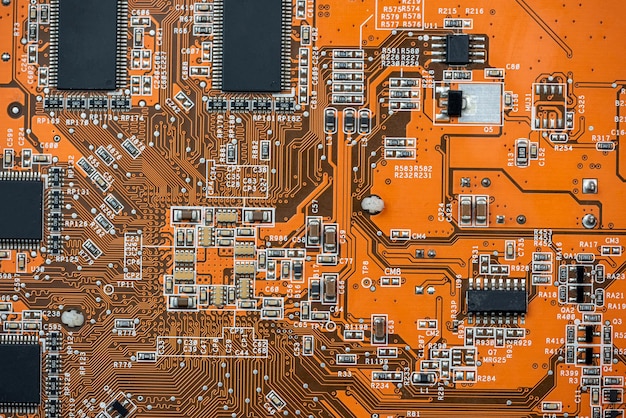Primer plano del componente de la computadora de fondo de la tecnología de la placa base de la placa de circuito naranja