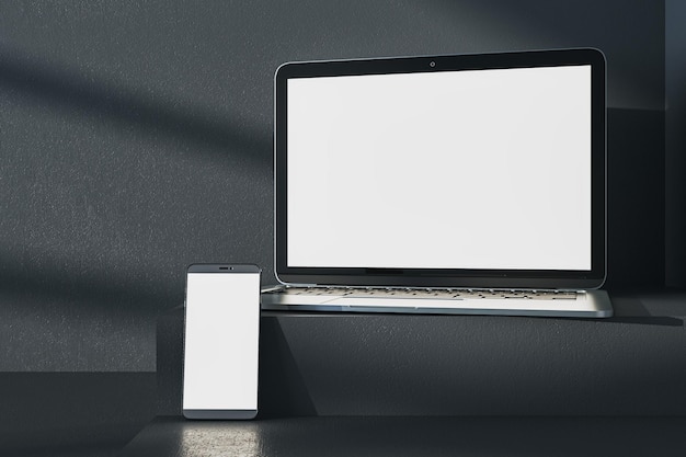 Primer plano de una computadora portátil blanca vacía y un teléfono en un escritorio gris oscuro Sombras de fondo de pared de hormigón y pedestal o podio Presentación de dispositivos y concepto de educación en línea Renderización en 3D