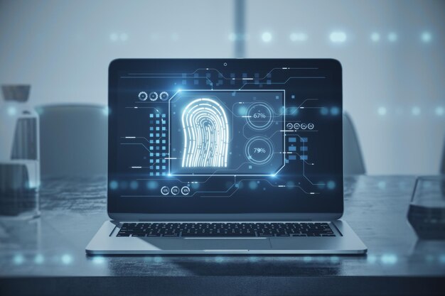 Primer plano de la computadora portátil en el escritorio con holograma creativo de huellas dactilares sobre fondo borroso tecnología de información biométrica de huellas dactilares y concepto de seguridad cibernética Doble exposición