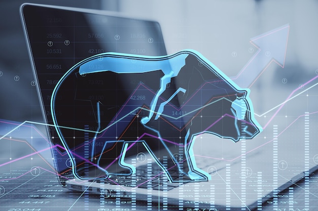 Primer plano de la computadora portátil con holograma abstracto de oso en el gráfico del mercado de valores financiero que representa el desplome del mercado de valores o la inversión de tendencia descendente en el fondo borroso Doble exposición