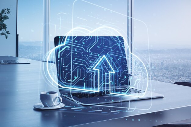 Primer plano de la computadora portátil con holograma de computación en la nube en el fondo de escritorio de la oficina borrosa con taza de café y ventana con vista a la ciudad Almacenamiento de datos y concepto de servidor Doble exposición