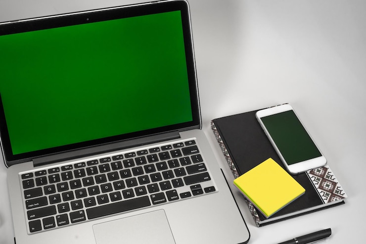 Foto primer plano de la computadora portátil y el teléfono con el libro en la mesa