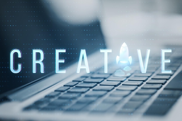 Primer plano de una computadora portátil con texto creativo y una nave espacial reemplazando la letra en un fondo borroso con círculos bokeh Piensa en la idea de comenzar a ser creativo e inspirar el concepto Imagen tonada
