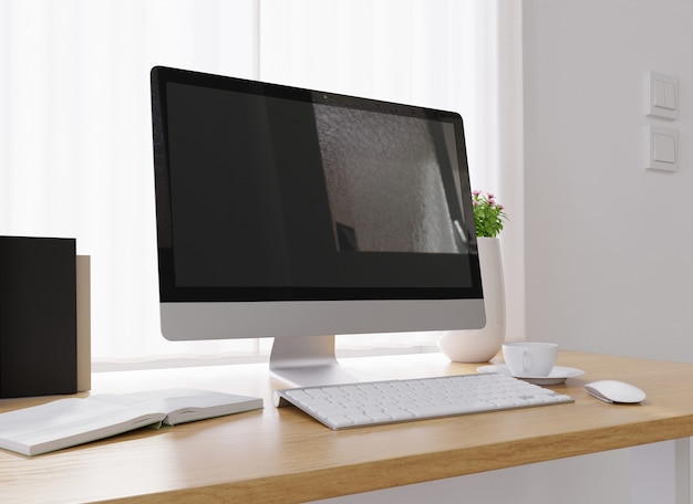 Primer plano de una computadora, una taza de café, un jarrón de flores y más en un escritorio blanco