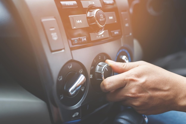 Primer plano del conductor manual que comprueba el interruptor que ajusta el aire del acondicionamiento del sistema de refrigeración con flujo de frío en el coche Deje espacio para escribir texto