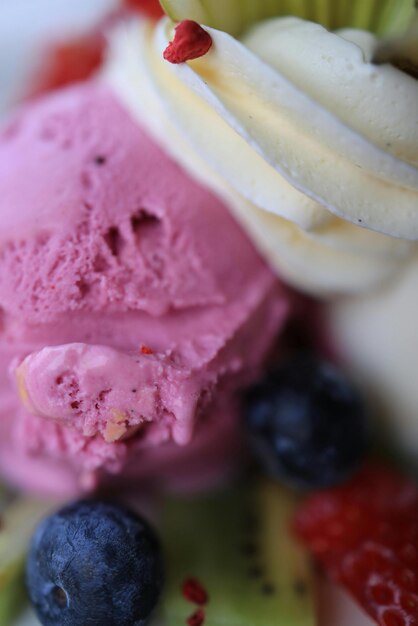 Foto un primer plano de un cono de helado rosa con arándanos y arándanos