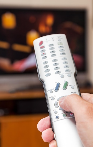 Primer plano del control remoto de TV con televisión