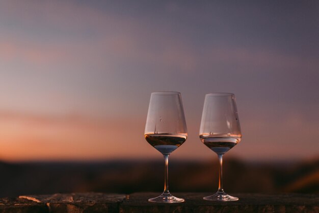 Primer plano de una copa de vino contra el cielo durante la puesta de sol