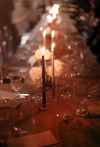 Primer plano de una copa de vino en la mesa con velas en un restaurante