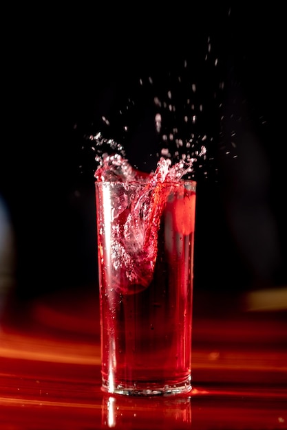 Primer plano de una copa de vino rojo contra un fondo negro
