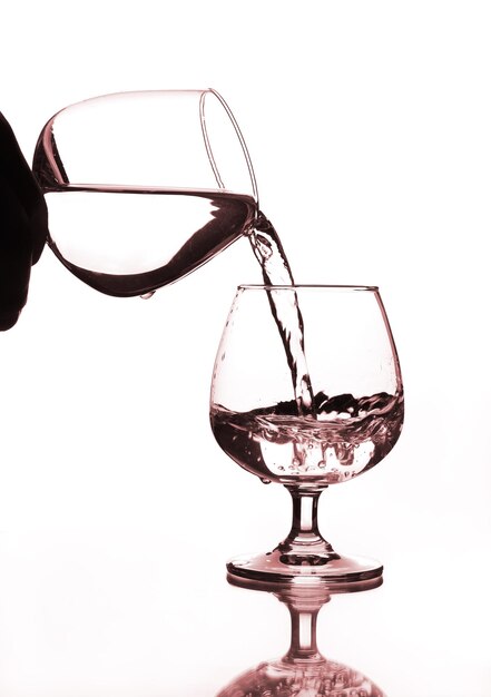 Foto primer plano de una copa de vino sobre vidrio contra un fondo blanco