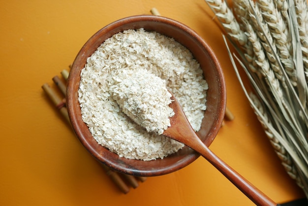 Primer plano de copos de avena tostados en una cuchara en la mesa