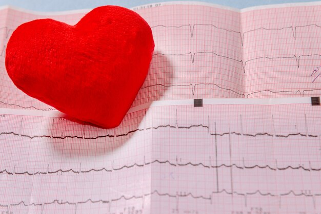 Primer plano de corazón rojo en el electrocardiograma (ECG). Cardiología, salud y concepto médico.