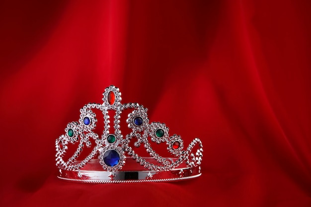 Primer plano de la corona contra la tela roja