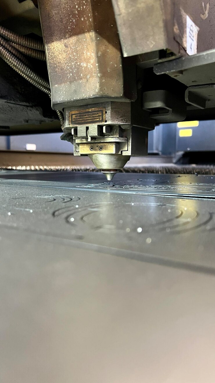 Foto primer plano de una cortadora láser industrial máquina de corte por láser que corta una placa de acero en la fábrica