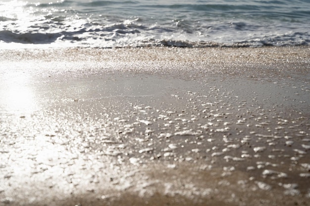 Primer plano en la costa del mar con el reflejo del sol en la arena Concepto de fondo abstracto