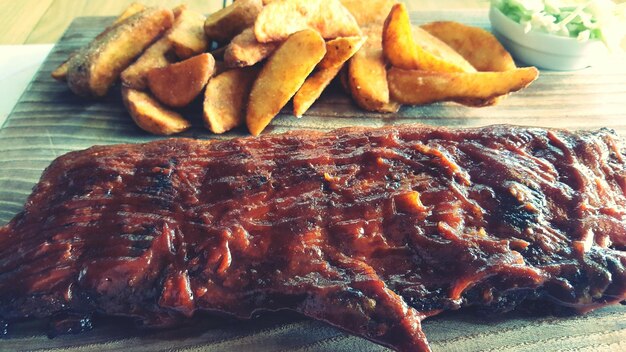 Primer plano de costillas de cerdo a la parrilla con patatas fritas