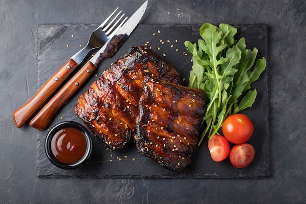 Primer plano de costillas de cerdo a la parrilla con salsa BBQ.