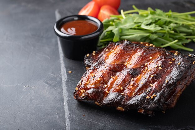 Primer plano de costillas de cerdo a la parrilla con salsa BBQ.