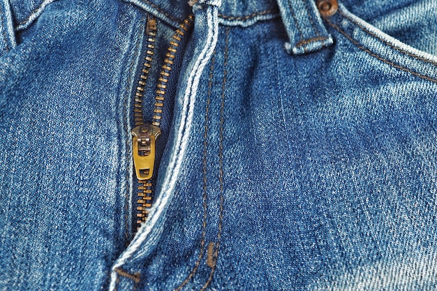 Primer plano de una cremallera de color cobre con viejos jeans.