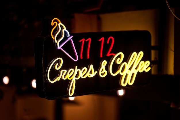 Foto un primer plano de las crepes, un letrero de café con luz de neón