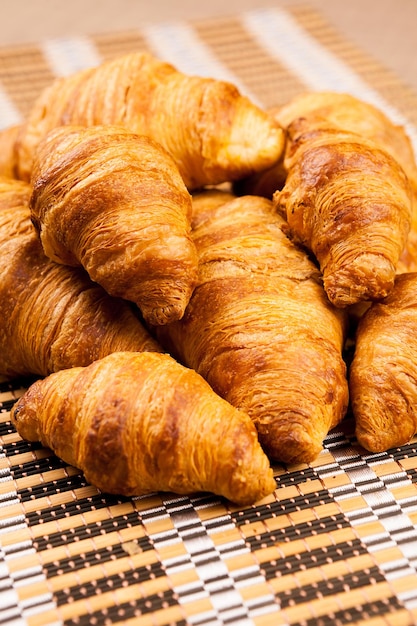 Primer plano de croissants dorados recién horneados sobre una mesa