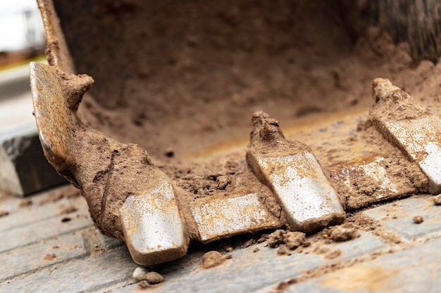 Primer plano del cucharón de la excavadora en el sitio de construcción Equipos de construcción para movimiento de tierras