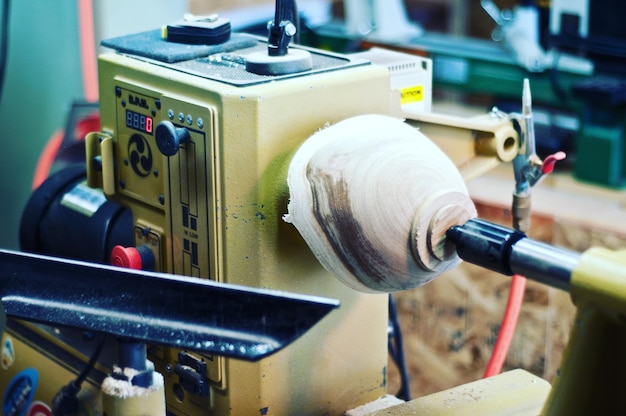 Foto primer plano de un cuenco de madera de una parte de la máquina en un torno