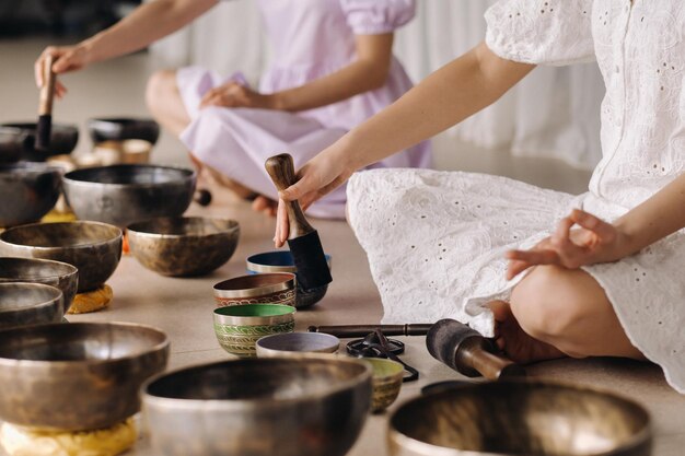 El primer plano de un cuenco tibetano en tus manos. La traducción de mantras transforma tu cuerpo, habla y mente impuros en un cuerpo, habla y mente puros y exaltados de un Buda.