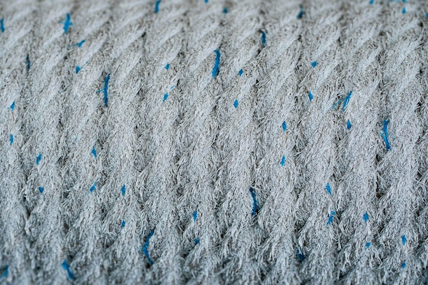 Un primer plano de la cuerda de fibra enrollada firmemente con manchas de hilos azules