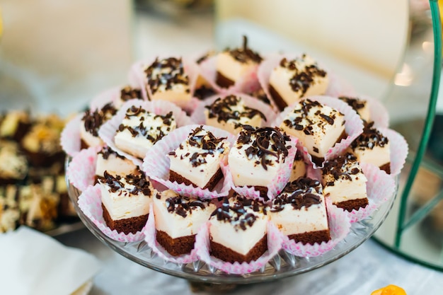 Primer plano de cupcakes con crema y chocolate en una boda de soporte transparente