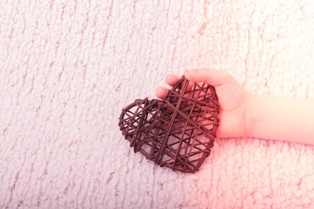 Foto primer plano de una decoración en forma de corazón con la mano en la alfombra