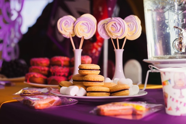 Primer plano de una decoración de mesa de color púrpura brillante para una fiesta de cumpleaños infantil dulces