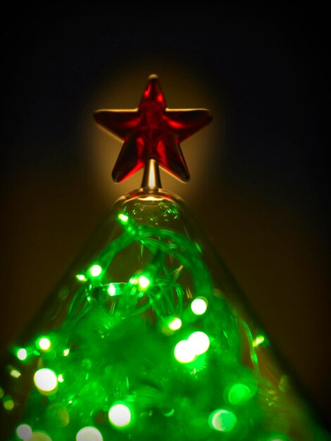 Foto primer plano de la decoración navideña iluminada en el cuarto oscuro