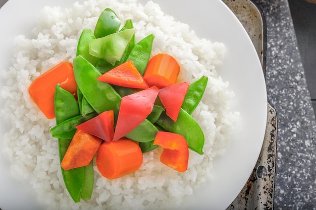 Primer plano delicia gourmet de arroz al vapor con vegetales cocidos en la parte superior capturado en resolución 4K