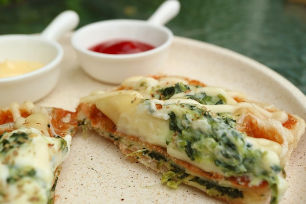 Primer plano de una deliciosa croffle salada rellena con espinacas y queso