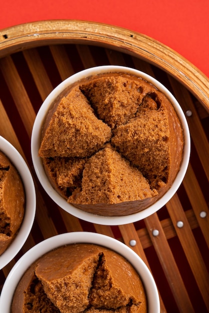 Primer plano de un delicioso bizcocho al vapor chino fresco llamado Fa Gao para la comida tradicional del festival de año nuevo lunar sobre el fondo de la mesa roja.