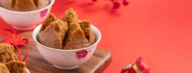 Primer plano de un delicioso bizcocho al vapor chino llamado Fa Gao para la comida tradicional del festival de año nuevo lunar sobre el fondo de la mesa roja.