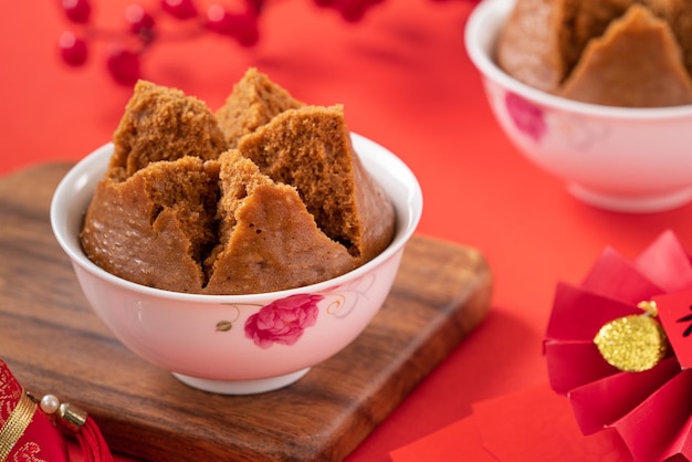 Primer plano de un delicioso bizcocho al vapor chino llamado Fa Gao para la comida tradicional del festival de año nuevo lunar sobre el fondo de la mesa roja.