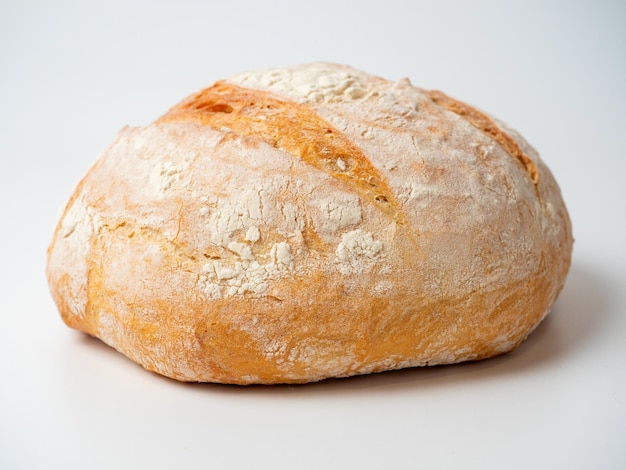 Un primer plano de un delicioso pan de trigo redondo fresco y crujiente sobre un fondo blanco Elementos aislados para hornear vista lateral