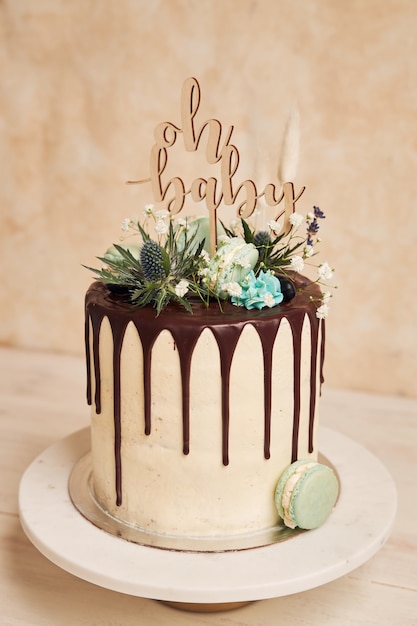 Primer plano de un delicioso pastel de goteo con un adorno de "oh baby" en él