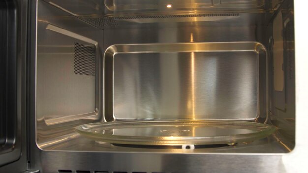 Primer plano de la demostración del espacio dentro del horno de microondas vacío utensilios domésticos nuevo modelo de