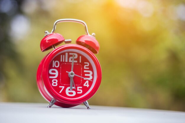 Foto primer plano del despertador rojo en la mesa en el patio