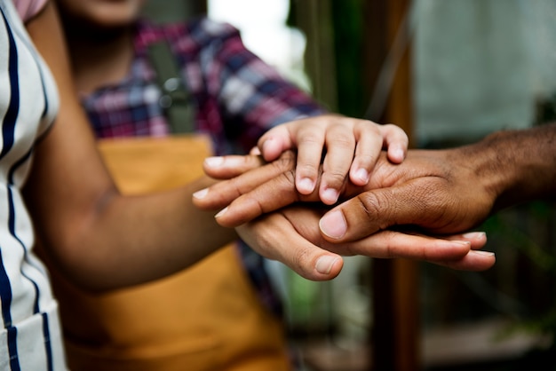 Primer plano de diversas manos unidas en equipo