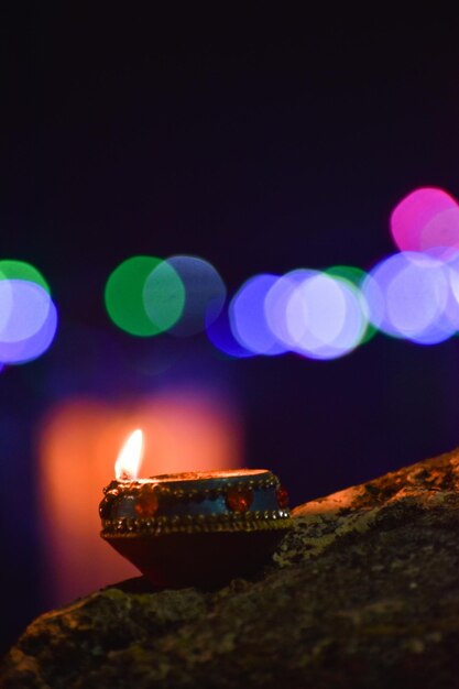 Foto primer plano de la diya encendida contra las velas