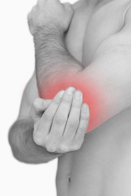 Primer plano de dolor en un codo sobre fondo blanco.