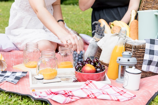 Primer plano de dos amigas disfrutando de la merienda en picnic